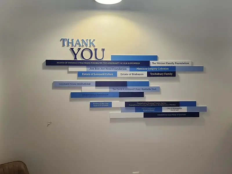A B&D capital-campaign donor recognition wall with engraved giving-level plates and a bold campaign graphic.
