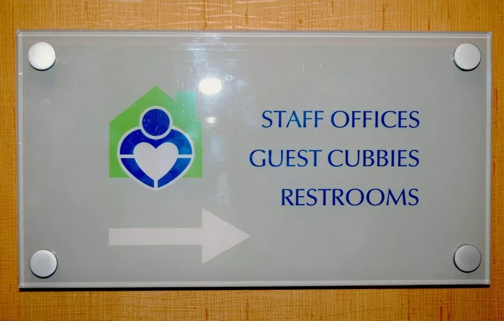 A B&D custom directional wayfinding sign guiding visitors through a facility interior.