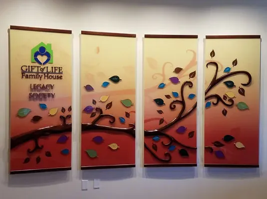 A free-form donor wall — adhesive-backed name plates in varied shapes and sizes arranged in a custom layout.