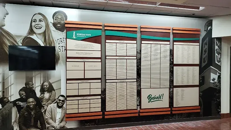 A B&D custom donor recognition wall at Norfolk University, with rows of engraved donor name plates arranged around a central graphic.