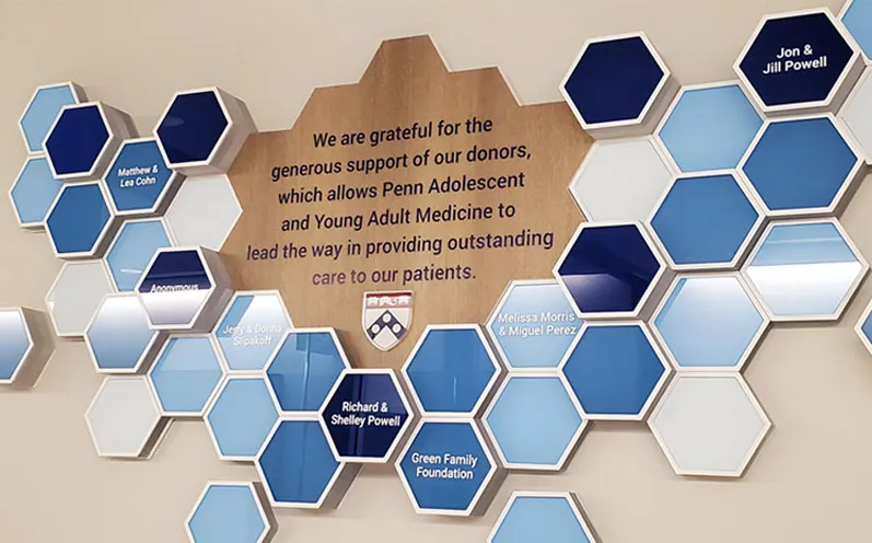 A side view of the Penn Medicine Radnor Campus donor wall, showing the depth of the individually mounted hexagon donor plaques.