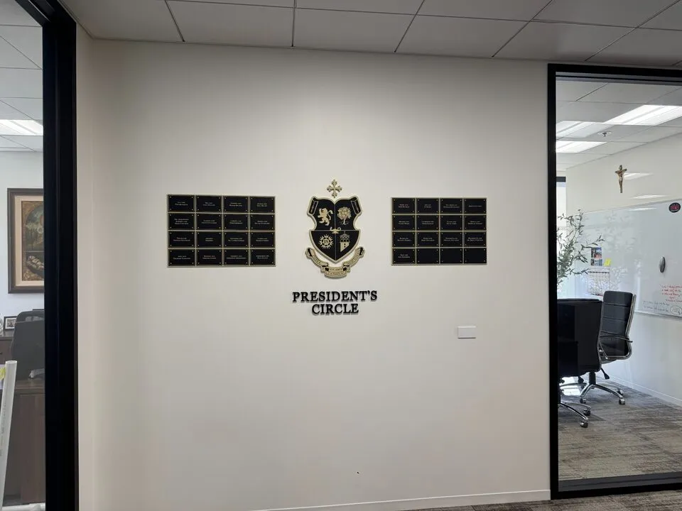 A B&D President's Circle donor recognition display with engraved name plates flanking a gold institutional crest.