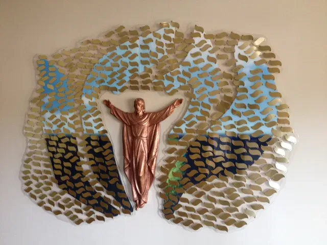 Resurrection donor display with a bronze figure of the risen Christ at the center, surrounded by radiating gold and blue engraved donor name plates.