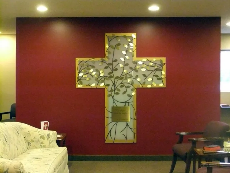 Donor recognition cross at St. John's, finished in wood tones with engraved donor name plates arranged around the cross.