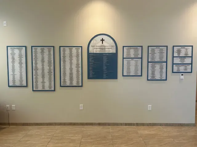 Custom donor recognition wall at Saint Joseph Catholic Church, with multiple framed donor honor-roll panels mounted in a bright lobby.