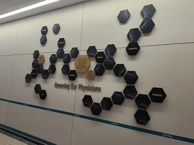 A B&D staff-recognition wall for Tower Health, with rows of engraved name plates across a paneled display.