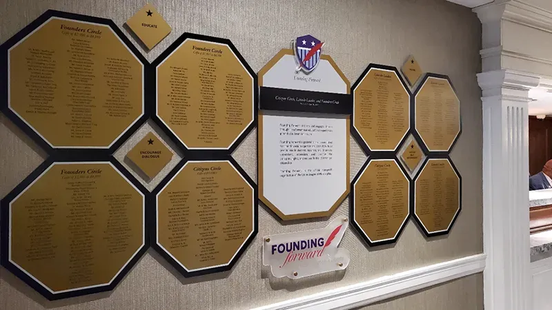 A B&D “Founding Forward” donor wall with octagonal gold name panels and a crest, honoring Founders Circle and Citizens Circle giving levels.
