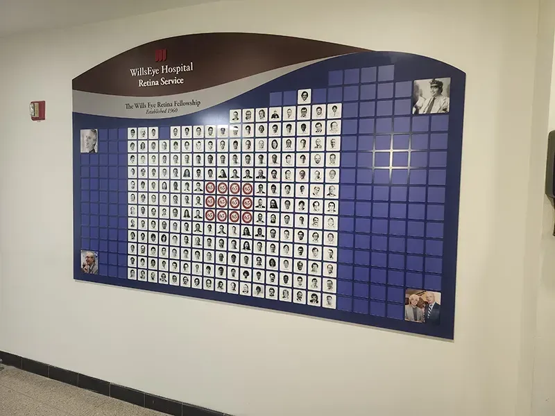 A B&D staff recognition environment at Wills Eye, with rows of engraved name plates across a paneled display.